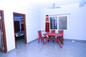 a dining room with a table and chairs and a window at Two Bedroom Flat Non AC Varun Vihar Near Horsley Hills in Kurabalakota
