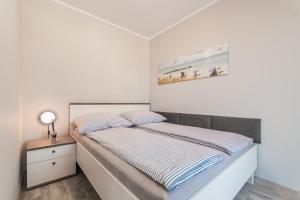 sypialnia z łóżkiem i obrazem na ścianie w obiekcie Apartament Baltic Sun N°37 w Sztutowie