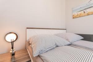 łóżko z poduszką i lampą w obiekcie Apartament Baltic Sun N°37 w Sztutowie +14 zdjęć