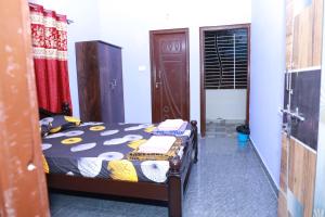 a bedroom with a bed in a room with a door at Two Bedroom Flat Non AC Varun Vihar Near Horsley Hills in Kurabalakota