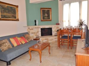 a living room with a couch and a fireplace at ΟΔΥΣΣΕΙΑ, κοντά σε αεροδρόμιο, λιμάνια και θάλασσες in Keratea