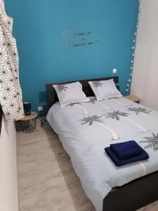 - une chambre dotée d'un lit avec un mur bleu dans l'établissement La forge, à Saint-Palais-sur-Mer