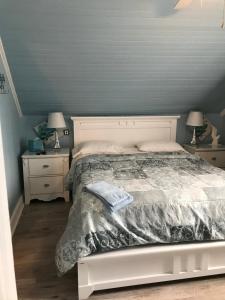 a bedroom with a bed and two night stands with lamps at gite des iles in Matane