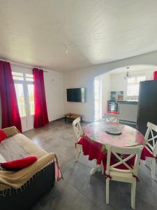 een woonkamer met een tafel en een bank bij Charmant appartement coloré proche de la plage in Bouillante