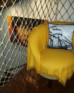 a yellow chair with a yellow blanket on it at Flat 14 Pipa in Pipa