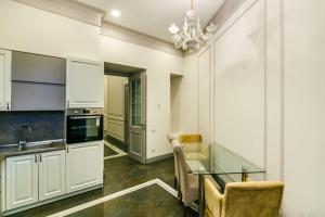 eine Küche mit weißen Schränken und einem Glastisch in der Unterkunft Apartment on Gold Baku in Baku