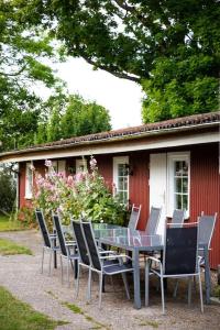 stół i krzesła przed czerwonym domem w obiekcie Mehrfamilienhaus auf Fehmarn 800m zum Strand w mieście Fehmarn