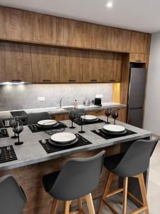a kitchen with a counter with chairs around it at Giannel Luxury Apartment 1 in Kastanéa