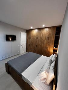 KastanéaにあるGiannel Luxury Apartment 1のベッドルーム1室(大型ベッド1台、木製ヘッドボード付)