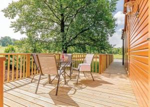 a wooden deck with a table and chairs on it at Cherry Tree Lodge in Narberth
