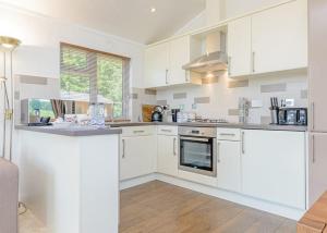 a kitchen with white cabinets and a counter top at Cherry Tree Lodge in Narberth