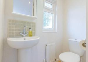 a white bathroom with a sink and a toilet at Cherry Tree Lodge in Narberth