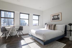 a bedroom with a bed and a table and windows at Reside Seattle Downtown, a Wyndham Residence in Seattle