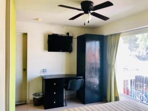 ein Schlafzimmer mit einem schwarzen Schreibtisch und einem Deckenventilator in der Unterkunft Hotel Ruah in Cuernavaca