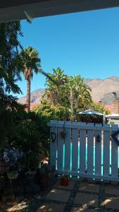 a porch with a white fence and palm trees at @Echeveria in Montagu