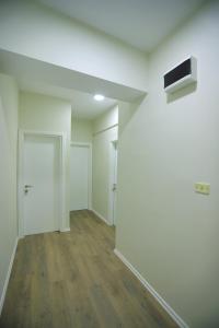 pusty pokój z białymi ścianami i drewnianą podłogą w obiekcie D1 Hostel w Tiranie