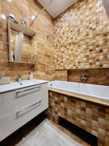 een badkamer met een bad, een wastafel en een bad bij E. D. Angel Wing Apartment in Šiauliai