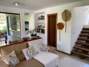 a living room with a couch with pillows on it at CASA PRAIA DO FORTE in Mata de Sao Joao +44 photos