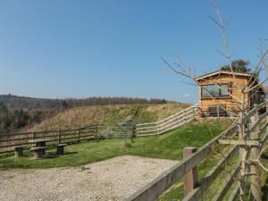 eine Holzhütte auf einem Hügel mit einem Zaun in der Unterkunft Castle View Cabin in Scarborough