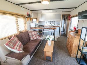 ein Wohnzimmer mit einem Sofa und einer Küche in der Unterkunft Castle View Cabin in Scarborough