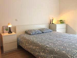 une chambre avec un lit et deux tables de nuit dans l'établissement Apartamento Mar com Parking, à Nazaré