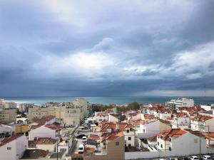 - une vue sur la ville avec ses bâtiments et l'océan dans l'établissement Apartamento Mar com Parking, à Nazaré