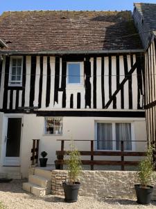 a black and white house with a wooden fence at maison chaleureuse en plein coeur de Livarot in Livarot