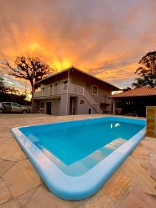 una gran piscina azul frente a una casa en Apartamento em chácara com piscina próximo de praias com internet en São Francisco do Sul