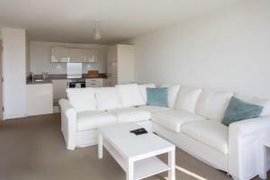 un soggiorno bianco con divano bianco e tavolo di Stunning 2 Bedroom Apartment in Ashley Down with Cricket View a Bristol
