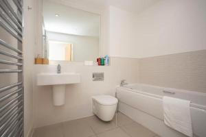 ein weißes Badezimmer mit einem Waschbecken, einem WC und einer Badewanne in der Unterkunft Stunning 2 Bedroom Apartment in Ashley Down with Cricket View in Bristol