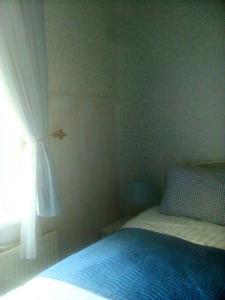 1 dormitorio con cama y ventana en Welsh Homestay, en Cardiff