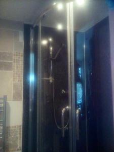 a shower with a glass door in a bathroom at Welsh Homestay in Cardiff