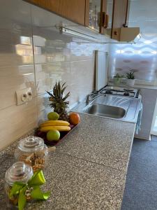 a kitchen with a counter with fruits and a sink at Apartman IVA, Donji Miholjac in Donji Miholjac