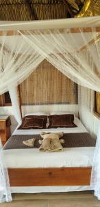 a bed with a teddy bear laying on it at San Simian Lodge in La Laguna