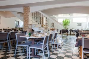 a restaurant with tables and chairs and a staircase at Le Petit Manoir Logis in Les Angles Gard