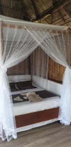 a bed in a room with a mosquito net at San Simian Lodge in La Laguna