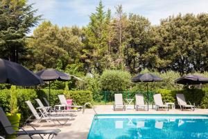 - une piscine bordée de chaises longues et de parasols dans l'établissement Le Petit Manoir Logis, aux Angles (Gard)