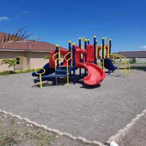 un parque infantil con un tobogán rojo en Relax Villa, en Ocho Ríos