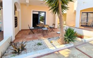 a patio with a table and chairs and a palm tree at Maria's Holiday House - Communal Pool in Paphos City