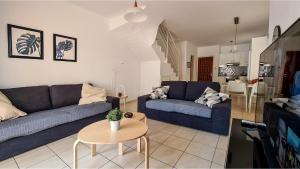 una sala de estar con 2 sofás azules y una mesa. en Maria's Holiday House - Communal Pool, en Pafos