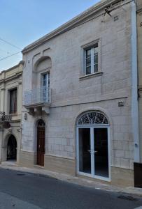 un gran edificio de piedra con puerta y balcón en Tal-Kampjin en Mellieħa