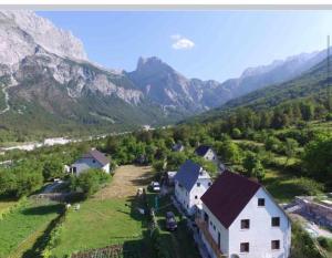 a house on a hill with mountains in the background at Bujtina Kometa in Theth
