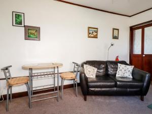 a living room with a leather couch and a table at The Annexe, Laburnum in Bugle