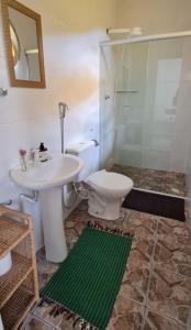 a bathroom with a toilet and a sink and a shower at Pousada Ilumina in São Francisco Xavier