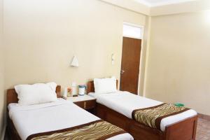Habitación pequeña con 2 camas y ventana en Baghmara Wildlife Resort en Sauraha