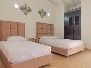 サンタ・マルタにあるHotel Los Veleros Santa Martaのベッド2台(壁にハート付)が備わるベッドルーム1室