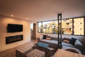 シエラネバダにあるAPARTAMENTO DE LUJO A PIE DE PISTA SIERRA NEVADAのソファと暖炉のあるリビングルーム