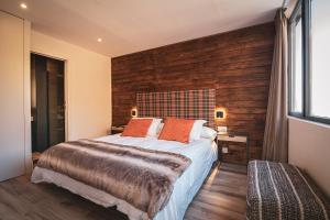 シエラネバダにあるAPARTAMENTO DE LUJO A PIE DE PISTA SIERRA NEVADAの大きなベッドと木製の壁が備わるベッドルーム1室が備わります。