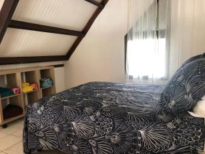 una camera con un letto con una coperta bianca e nera di VIVA a Le Gosier