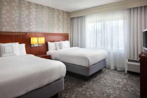 a hotel room with two beds and a television at Sonesta Select Laguna Hills Irvine Spectrum in Laguna Hills